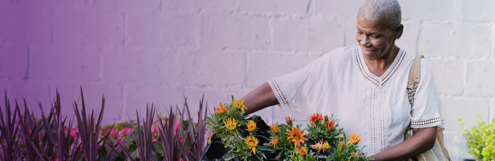 elderly woman tending flowers in a garden